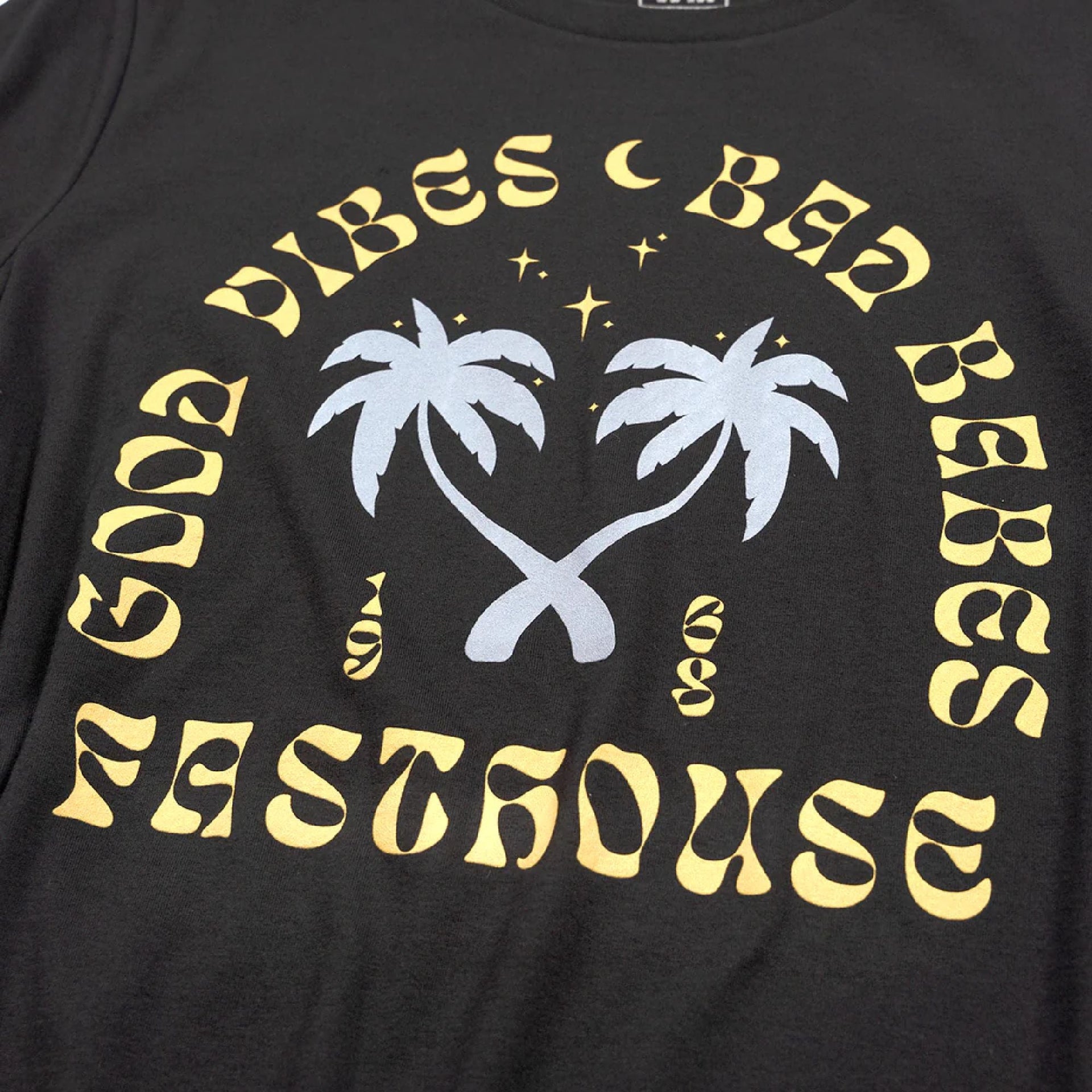 Women's black tee with large palm-and-logo graphic print on the front