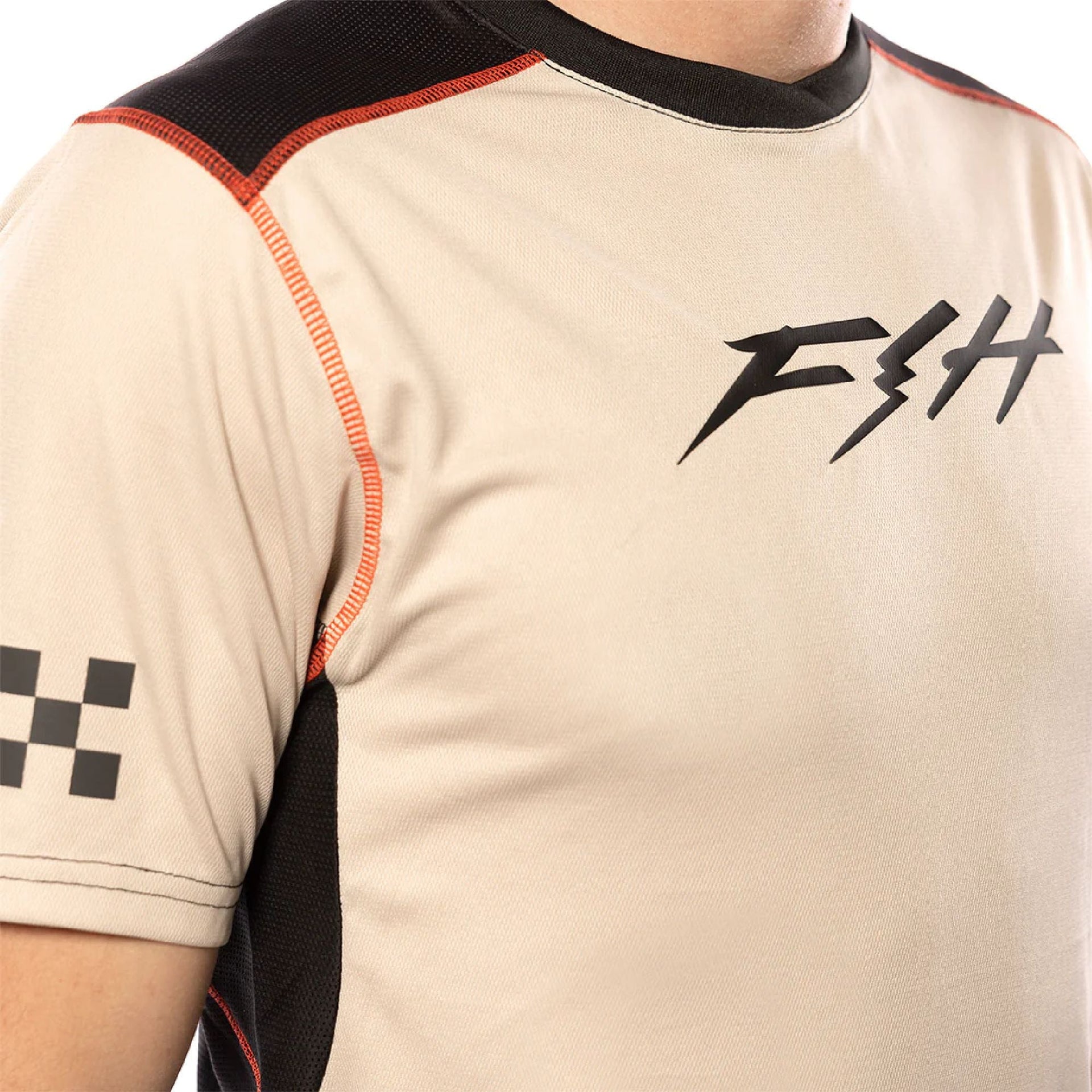 Youth short-sleeve jersey close-up, cream with white logo and orange edge stitching