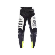 Youth riding pants, black with white panels, checkered waistband, skull graphic, neon yellow