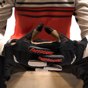 Black youth riding glove with red Fasthouse logo and contrast thumb padding
