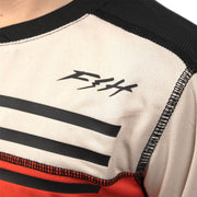 Youth motocross jersey chest close-up with stripe bands, small logo, and black neckline trim