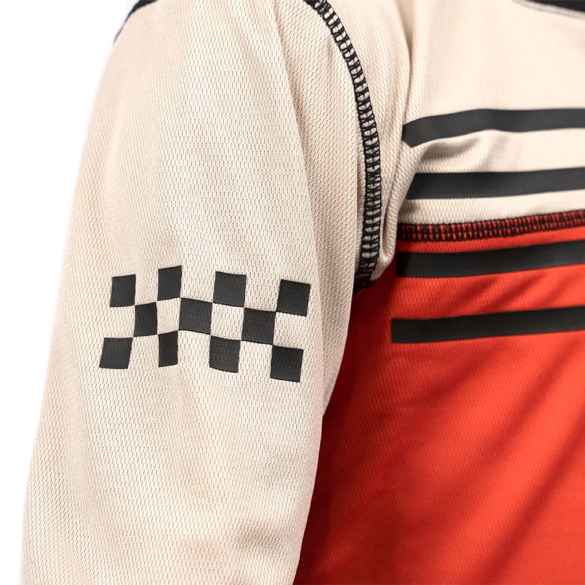 Youth long-sleeve motocross jersey sleeve detail with black checkered graphic on cream fabric