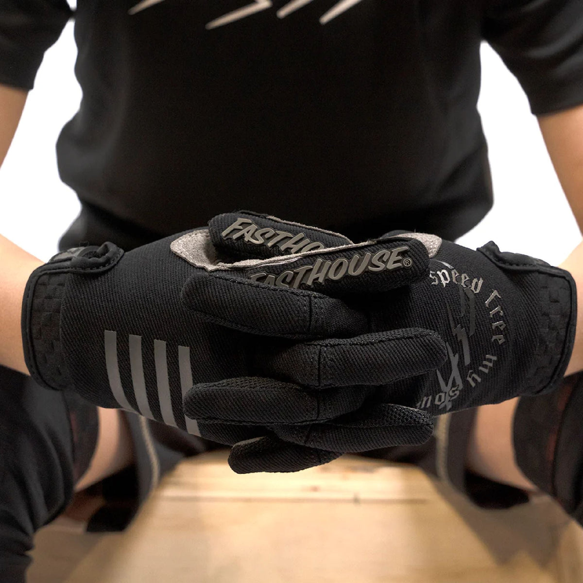 Black youth riding gloves close-up with Fasthouse patch and grip-style wrist cuff