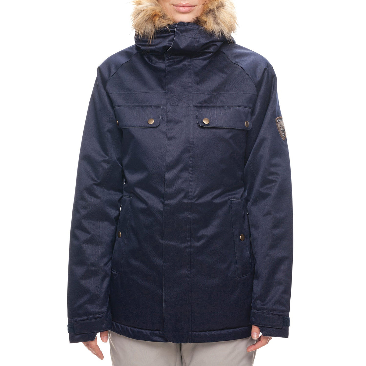 Women’s insulated jacket with navy shell, fur-trimmed hood, and snap front pockets