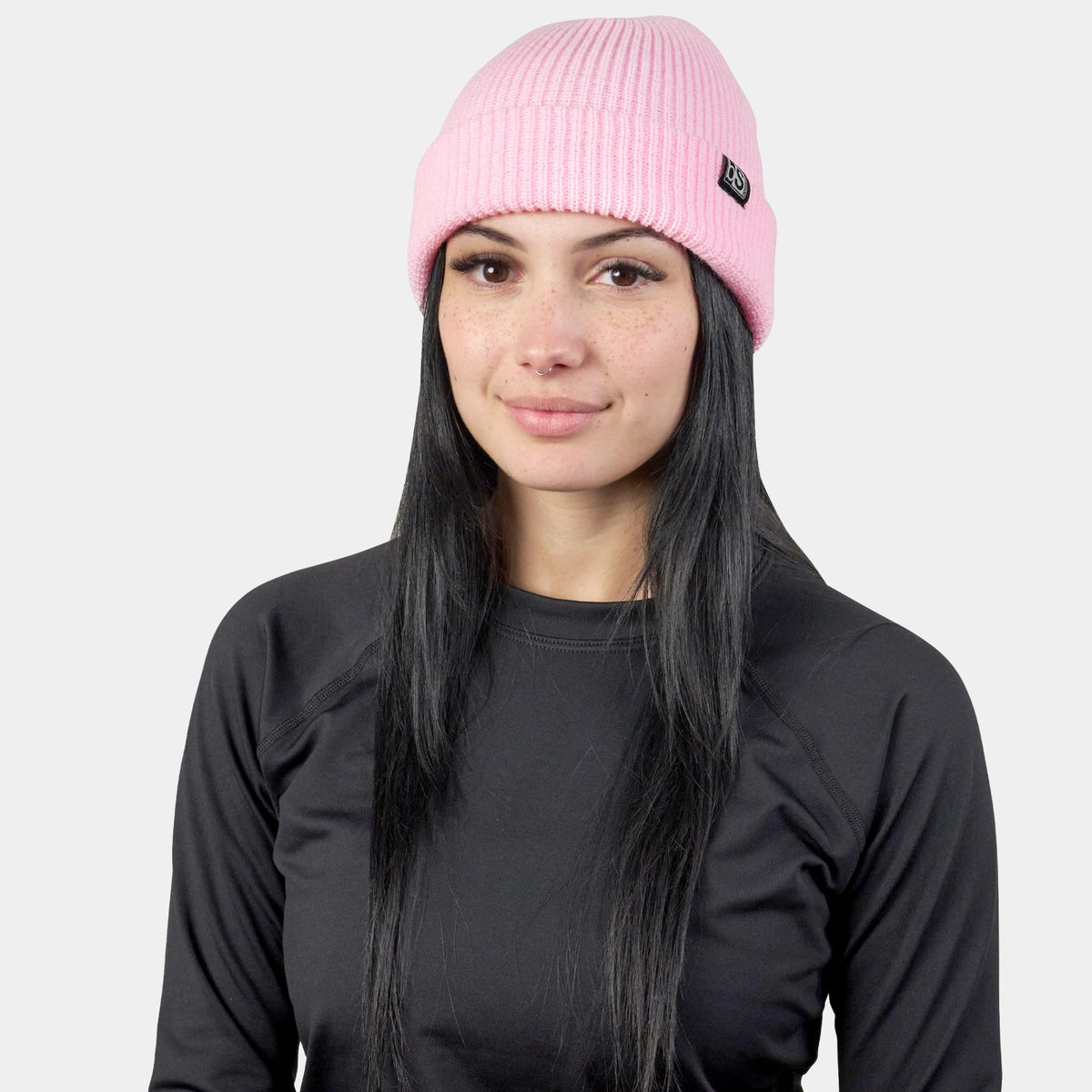 Pink knit beanie with BLACKSTRAP logo patch, worn on head