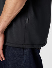 Black crew-neck T-shirt with brand label at the side seam near hem.